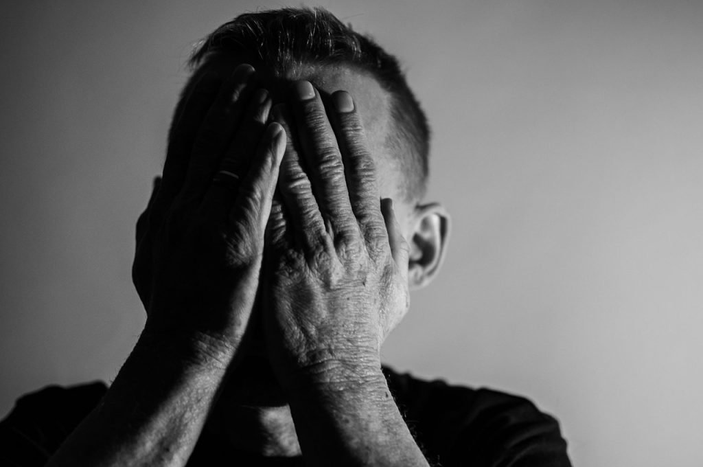 Man covering his faces with his hands